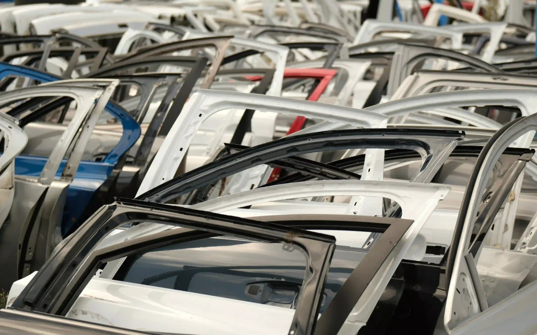 Rows of stripped car door frames stacked at a scrap yard, ready for metal recycling and parts salvage