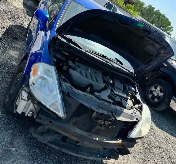Blue damaged junk car with exposed engine and missing bumper, ready for scrap car removal in Toronto