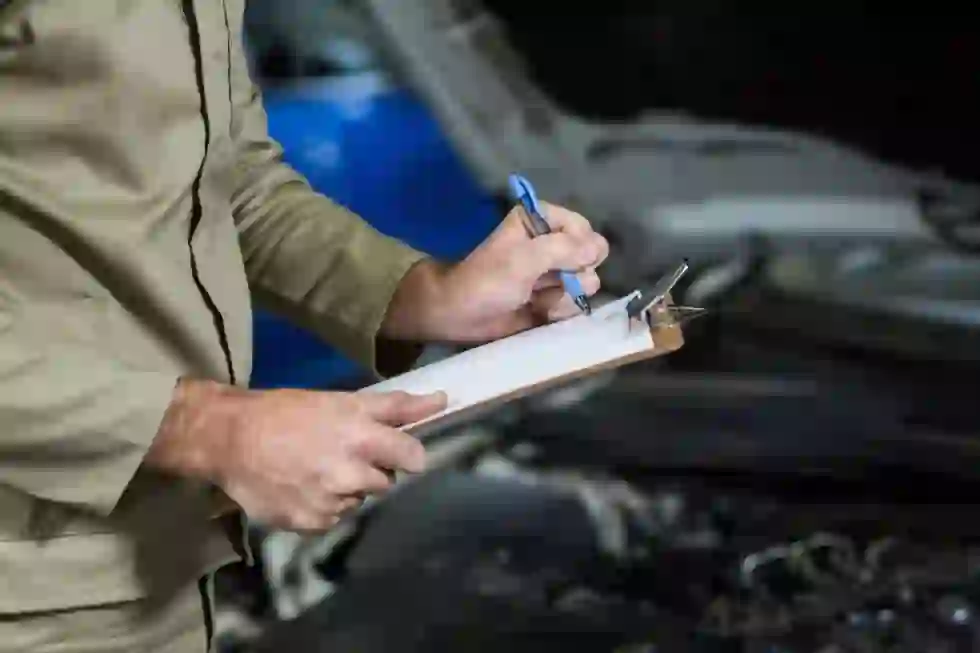 A scrap car buyer inspecting a vehicle and reviewing paperwork on a clipboard before pickup