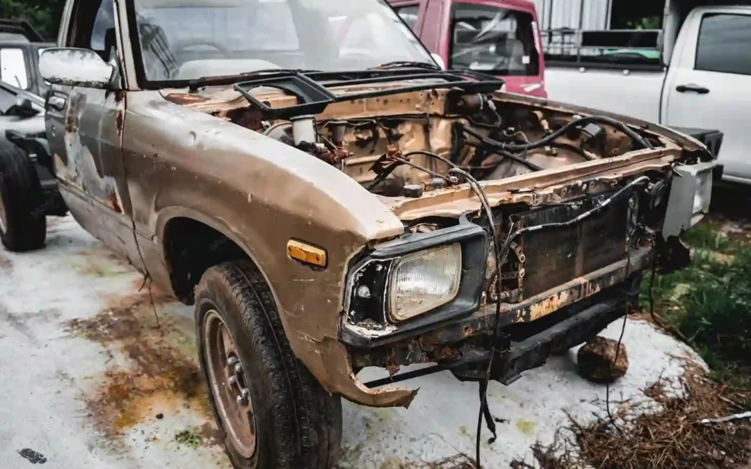 Rusty stripped car in a junkyard