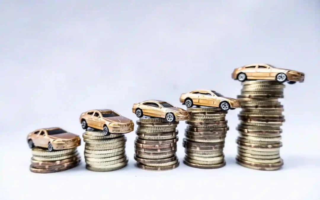 Miniature gold toy cars perched on ascending coin stacks, symbolizing rising scrap car value as metal prices climb