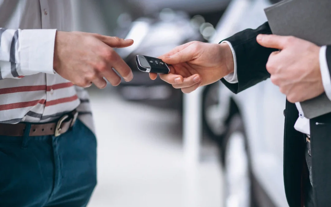 car owner handling the car keys to next person after vehicle ownership transfer